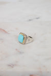 Turquoise squared center stone with gold and diamond border details and side stamping in hardware