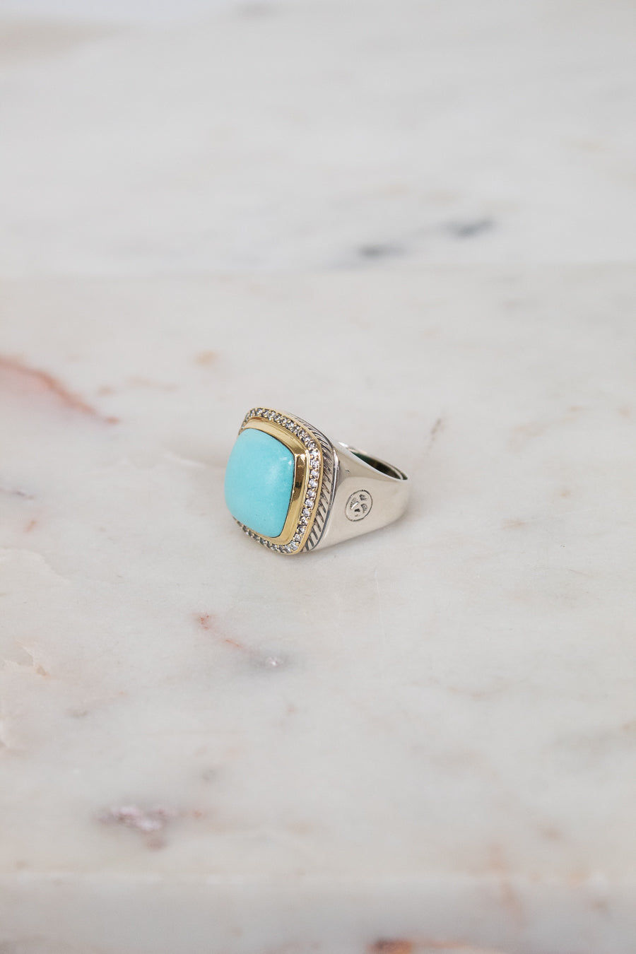 Turquoise squared center stone with gold and diamond border details and side stamping in hardware