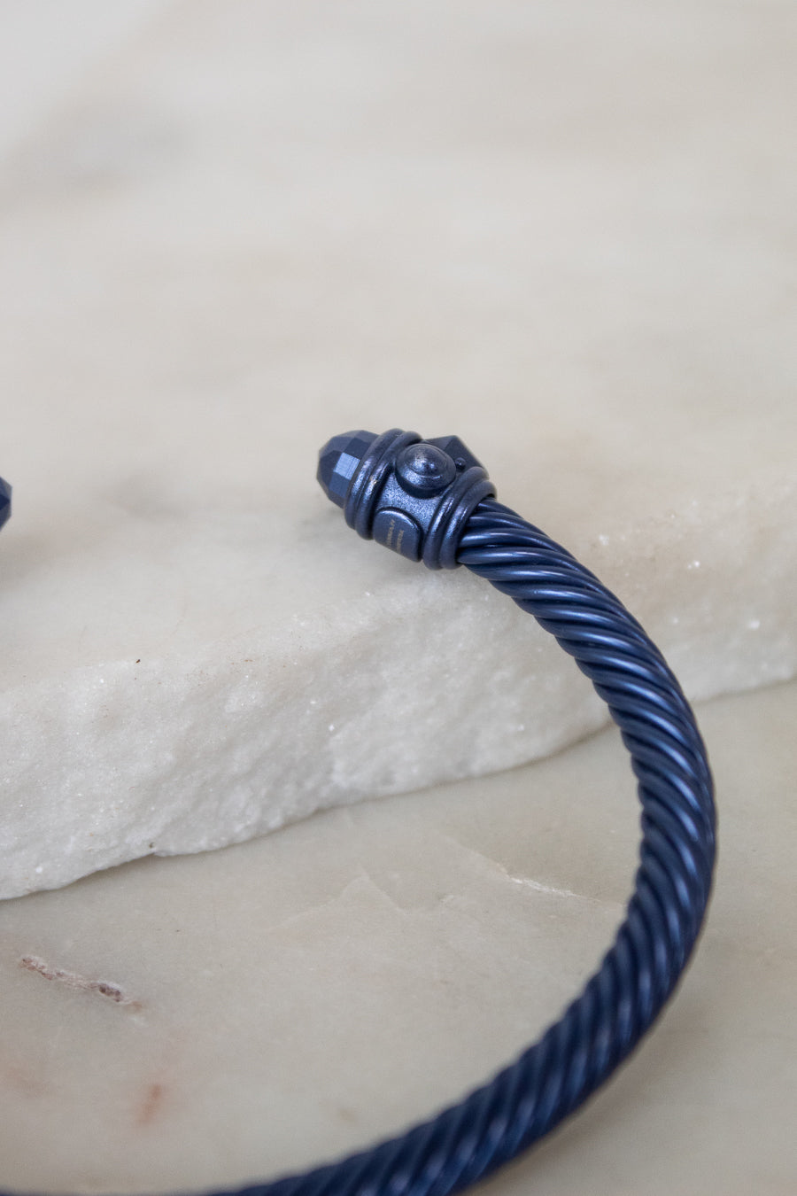 Blue cable bracelet on a light stone surface