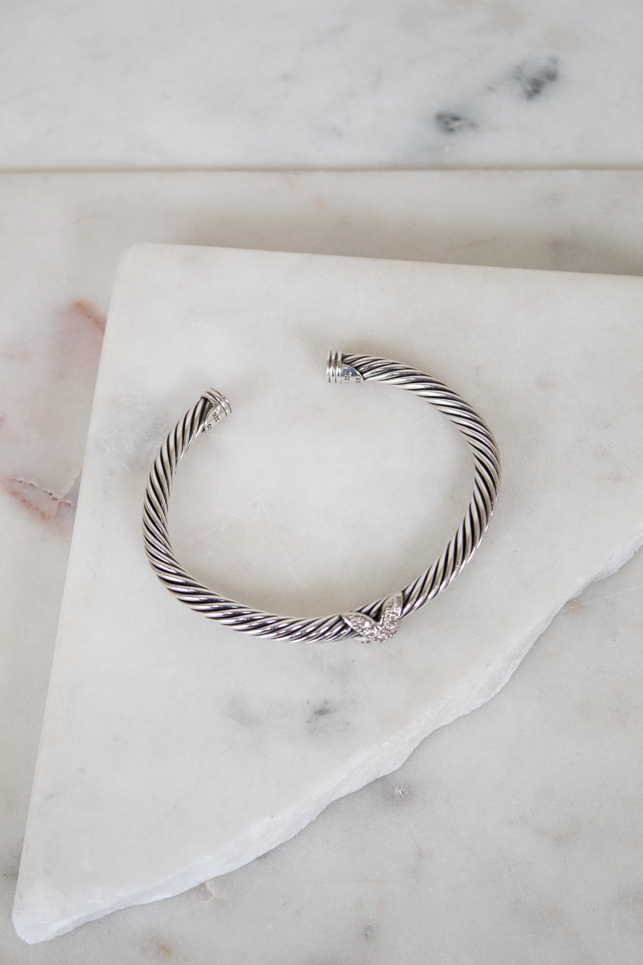 Silver bracelet cuff on a marble surface