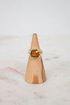 Oval citrine stone face ring on wooden stand