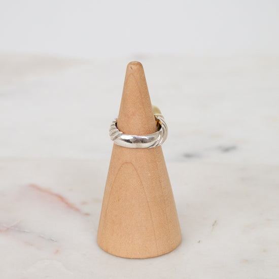 Back view of silver ring on wooden stand