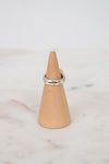 Back view of silver ring on wooden stand