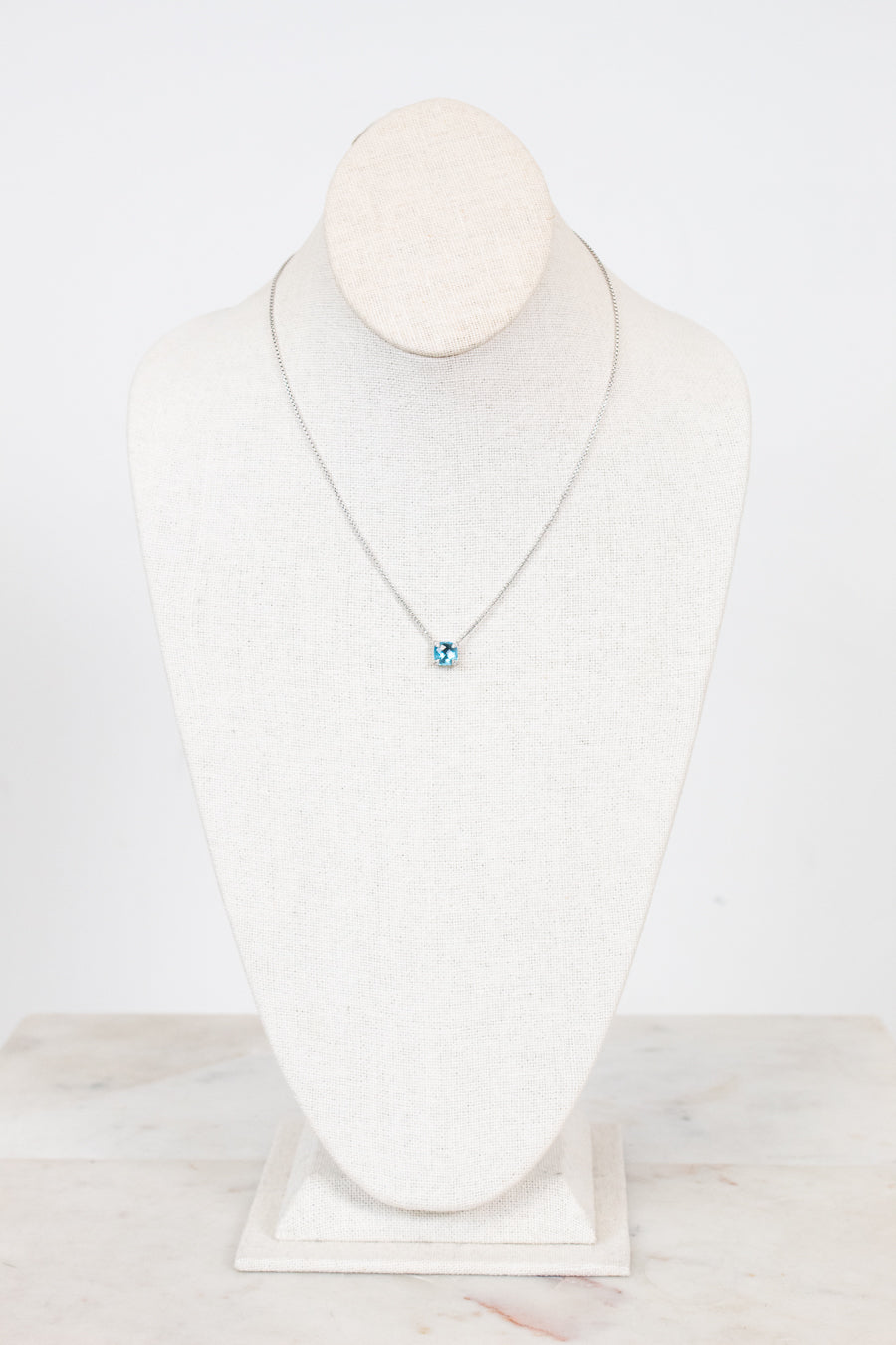 Necklace with a blue center detail on a mannequin against a white background