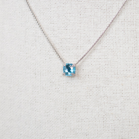 Necklace with a blue gemstone on a light gray background