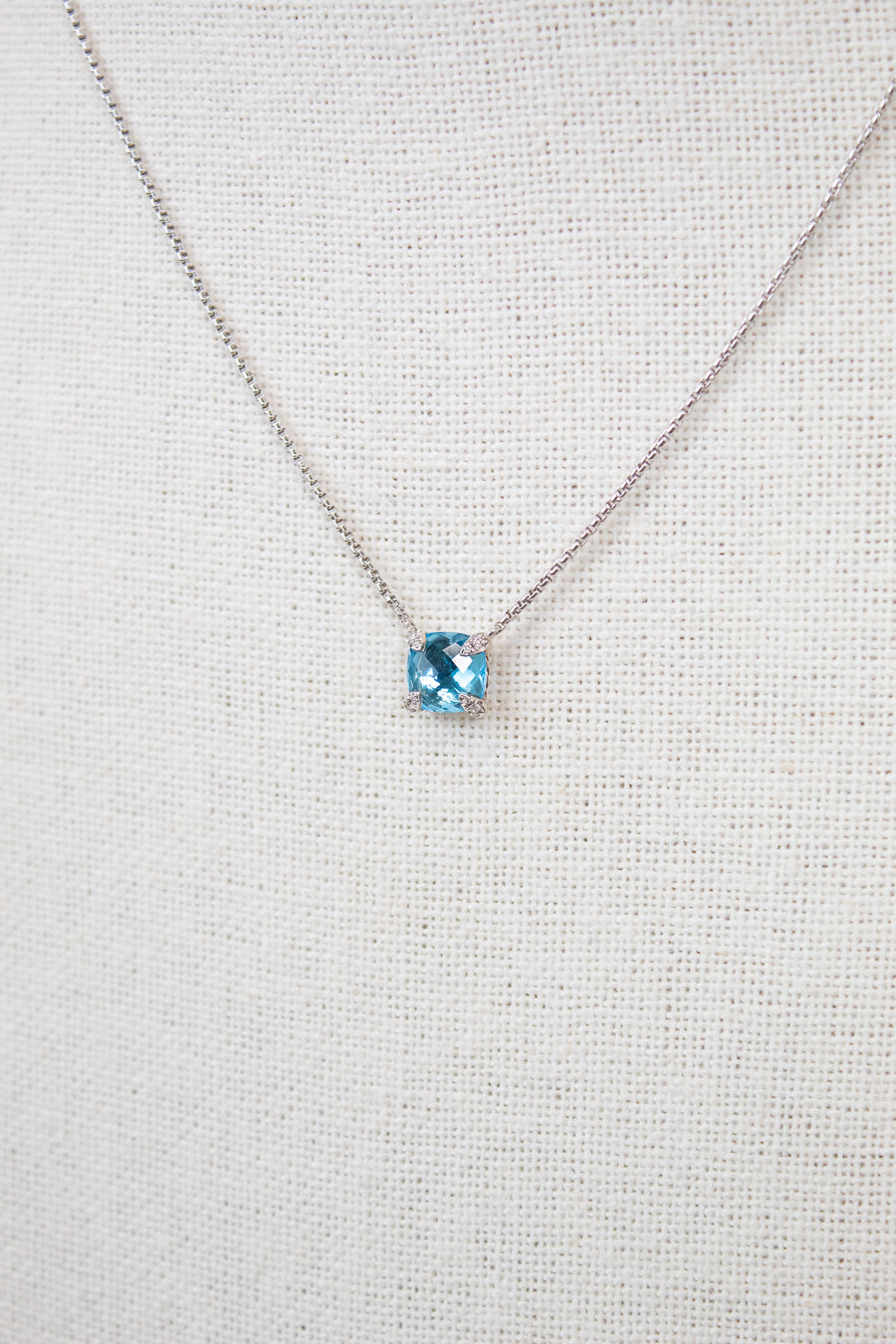 Necklace with a blue gemstone on a light gray background