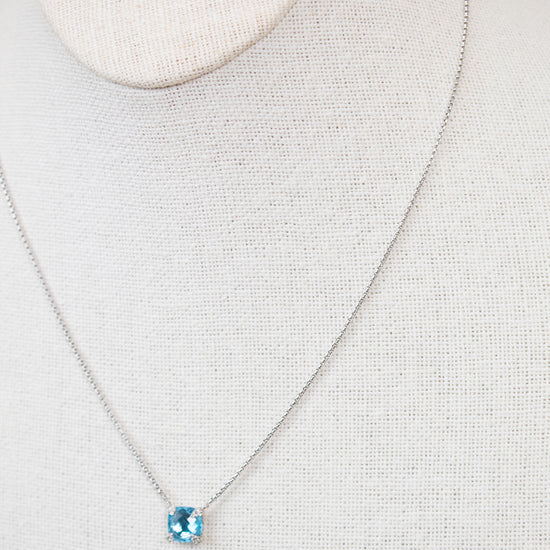 Necklace with a blue center stone detail on a mannequin neck against a neutral background