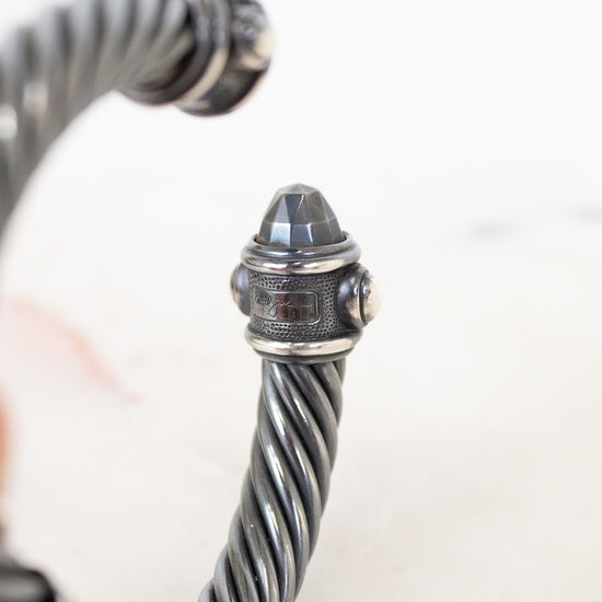 Close-up of a silver bracelet with intricate design on a light background