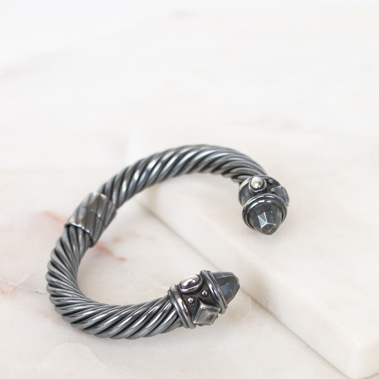 Silver bracelet with a detailed design on a white surface