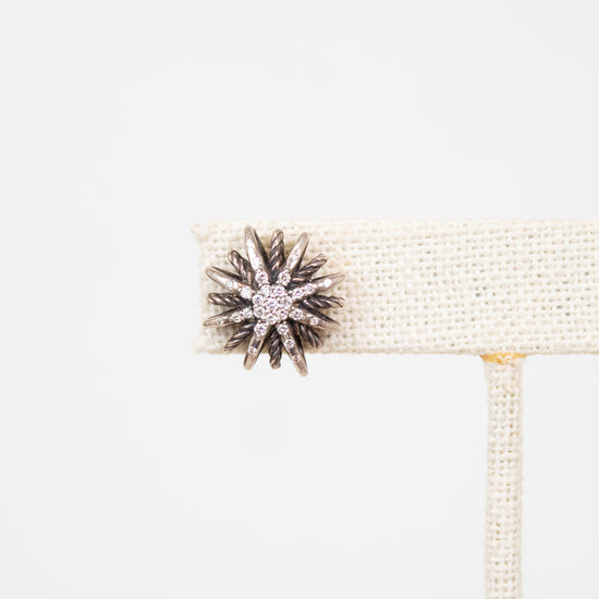 Close up of silver and diamond earring on white background