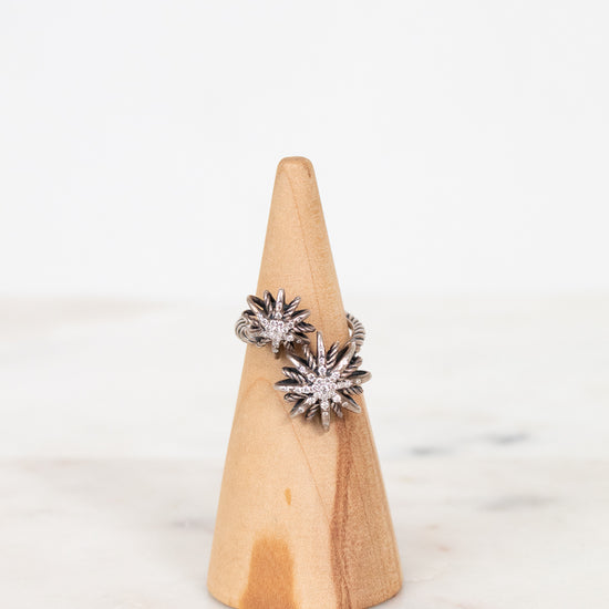 Silver diamond ring on wooden cone with white background