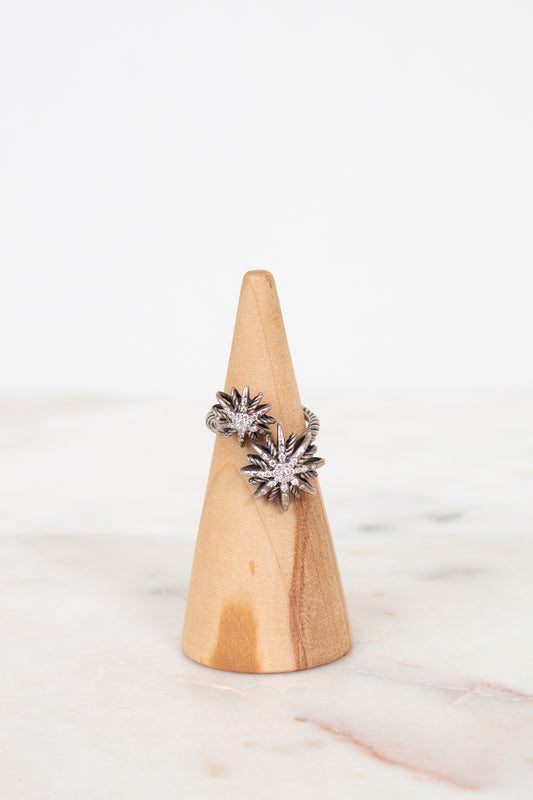 Silver diamond ring on wooden cone with white background