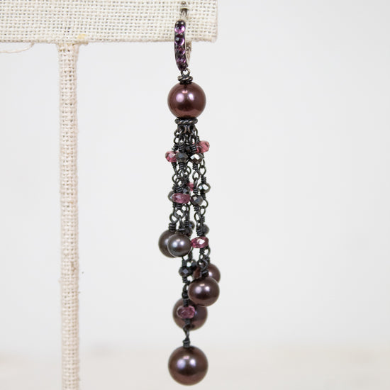 Pair of dangling pearl earrings on a white background
