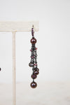 Pair of dangling earrings with pearls and beads on a white background