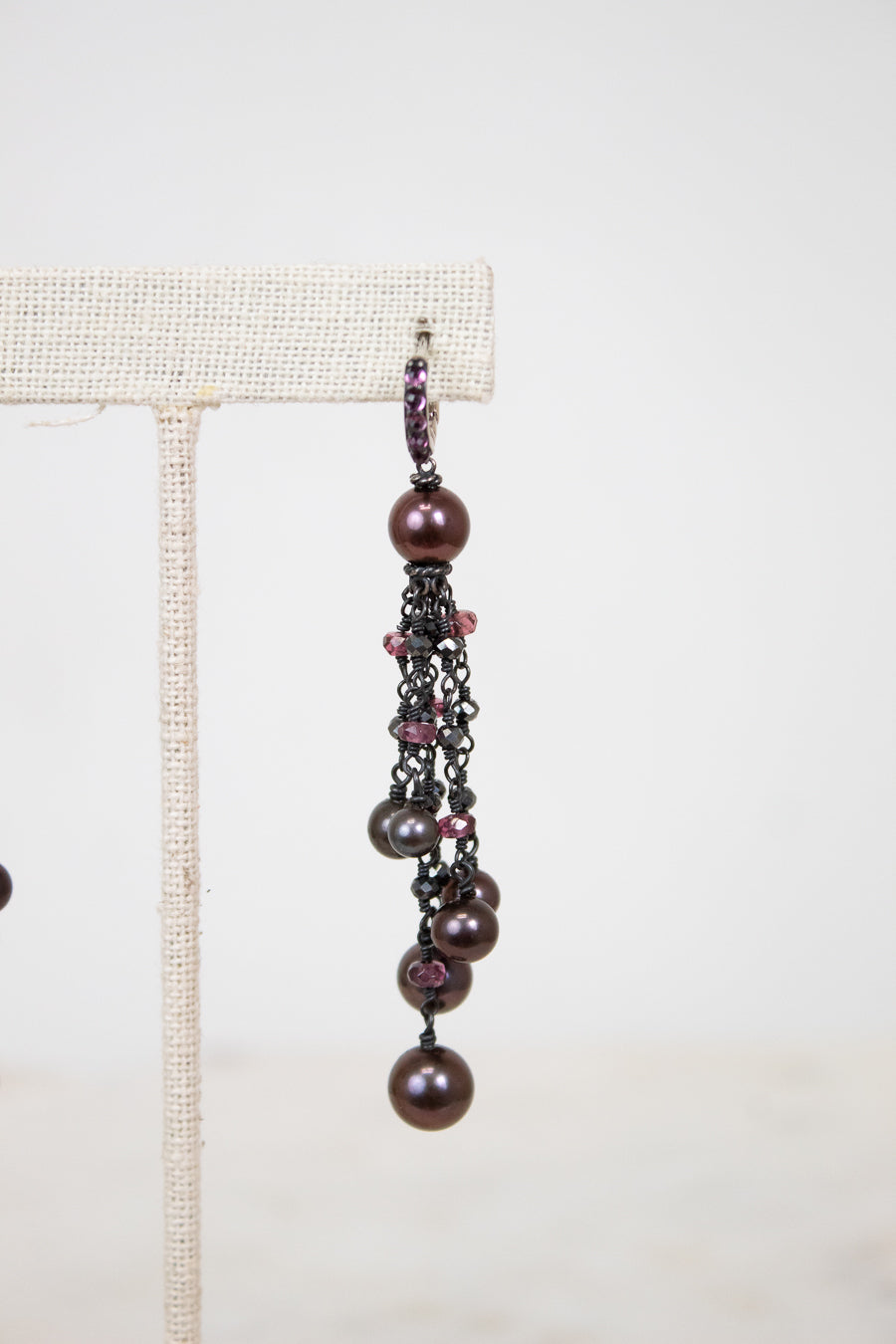 Pair of dangling earrings with pearls and beads on a white background