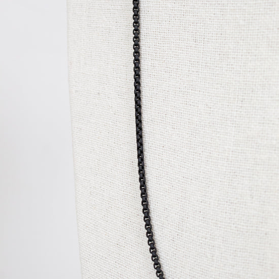 Black chain necklace on a white fabric background