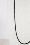 Black chain necklace on a white fabric background