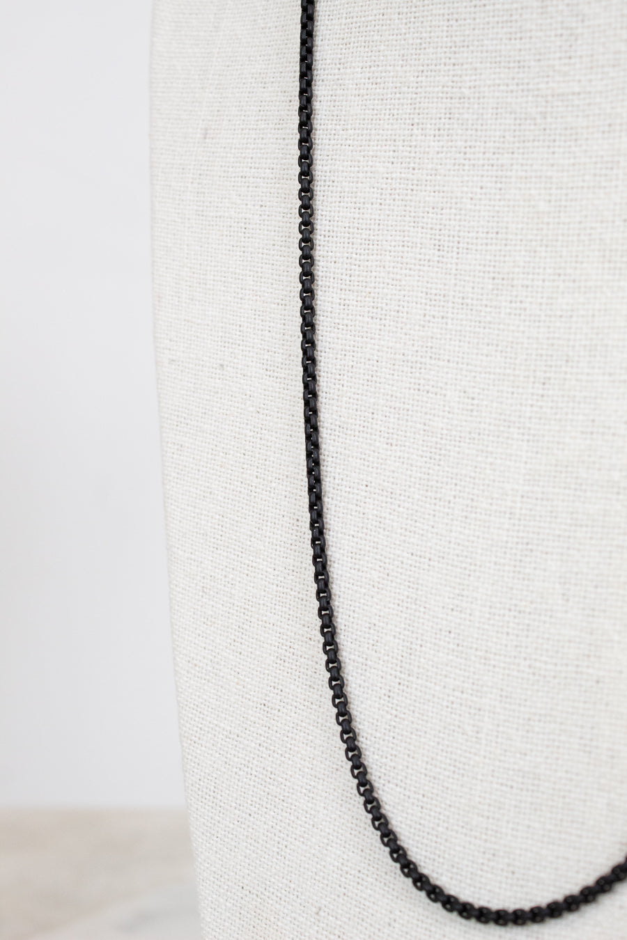 Black chain necklace on a white fabric background