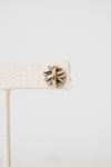 Close up of a silver and gold layered overlap 'X' stud earrings displayed on plain white background