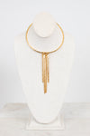 A gold-toned choker necklace with three dangling chain fringe elements, displayed on a white fabric jewelry bust against a clean white background.