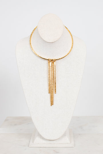A gold-toned choker necklace with three dangling chain fringe elements, displayed on a white fabric jewelry bust against a clean white background.