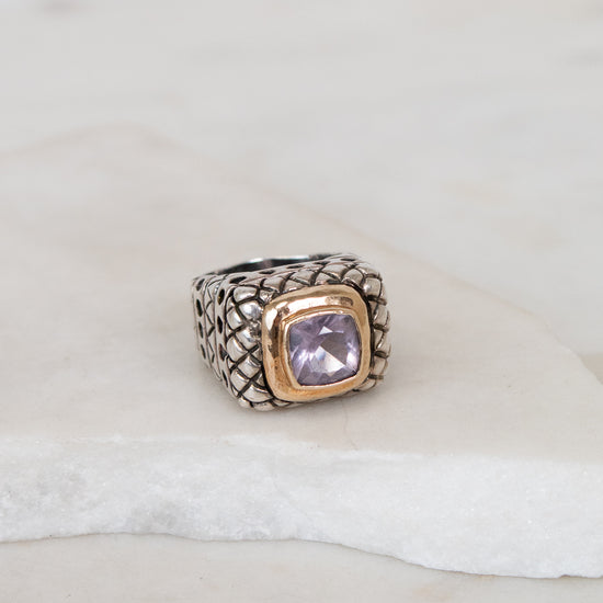 Ring with a purple gemstone on a white surface
