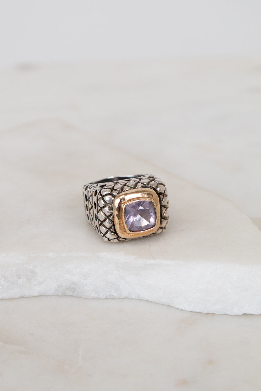 Ring with a purple gemstone on a white surface