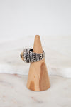 Silver ring on a wooden stand with a white background