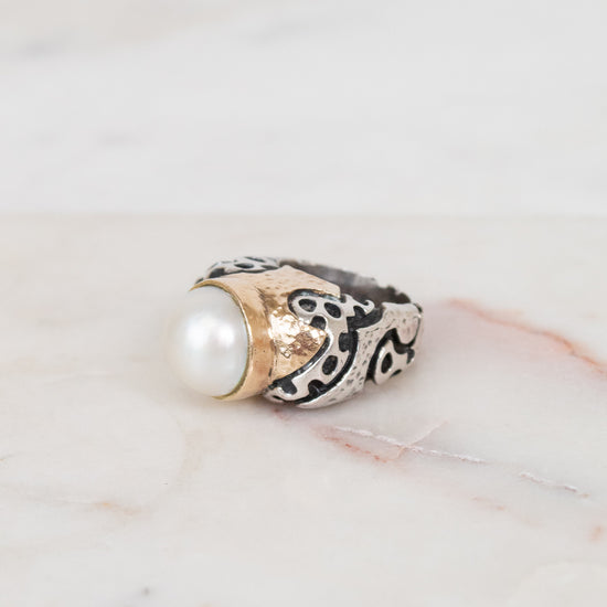Ring with pearl and design on a marble surface