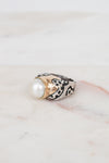 Ring with pearl and design on a marble surface