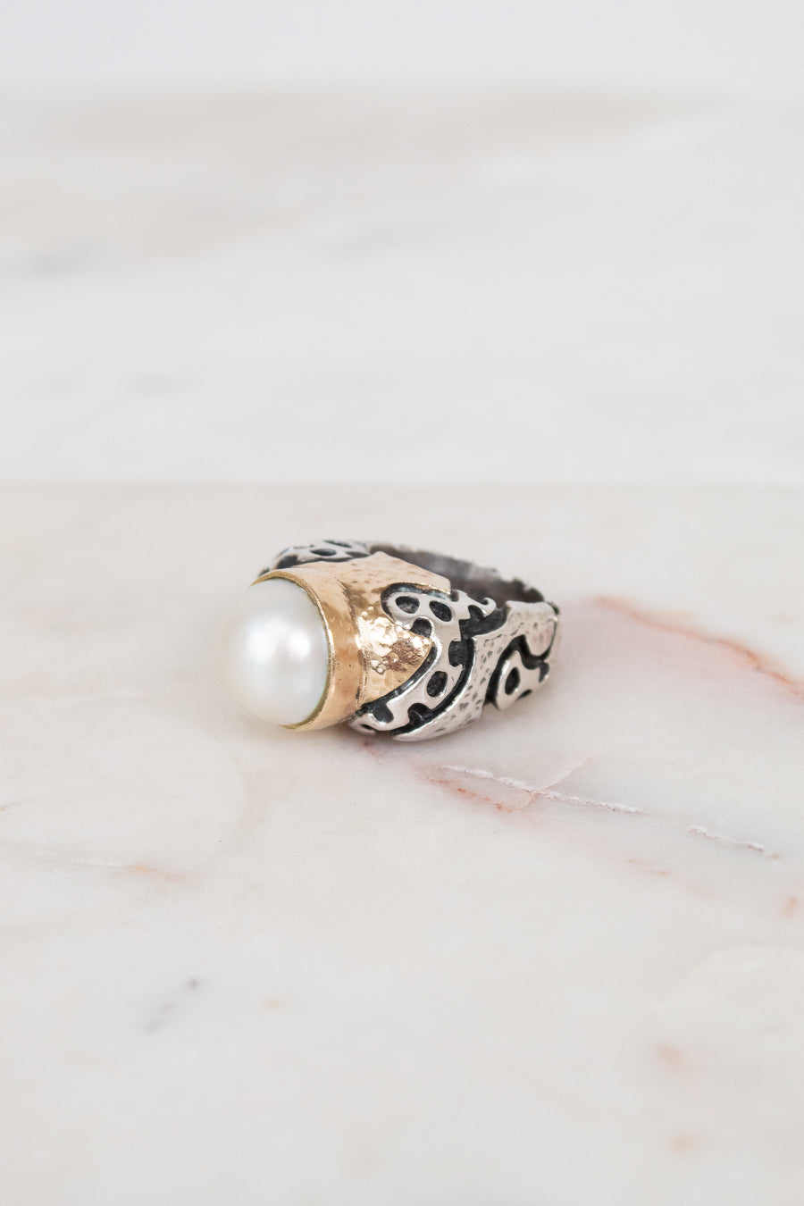 Ring with pearl and design on a marble surface