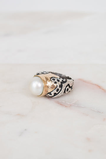 Ring with pearl and design on a marble surface