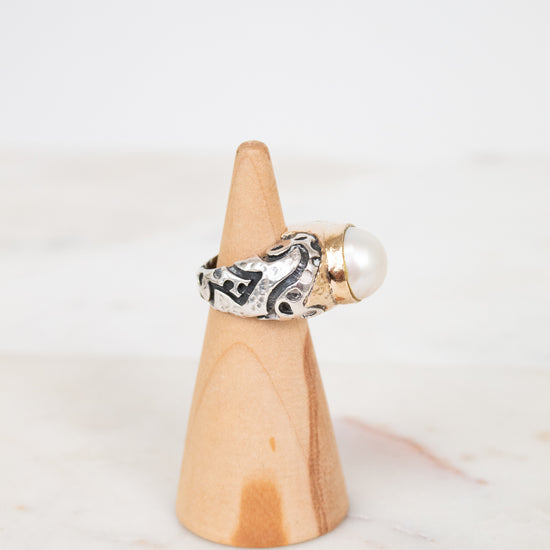 Ring on a wooden cone with a white background