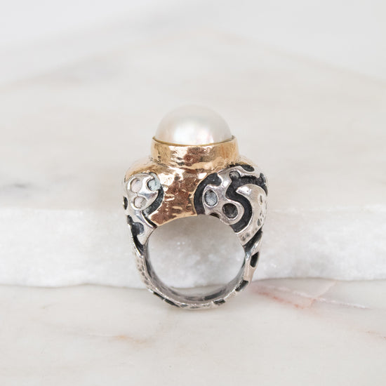 Ring with pearl detail on a marble surface
