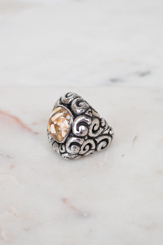 Silver ring with a central mixed stone on a marble surface