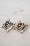 Pair of square-shaped earrings with animal print design on a marble surface