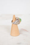 Ring with a turquoise stone on a wooden stand against a white background
