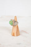 Two toned ring on a wooden cone with a white background