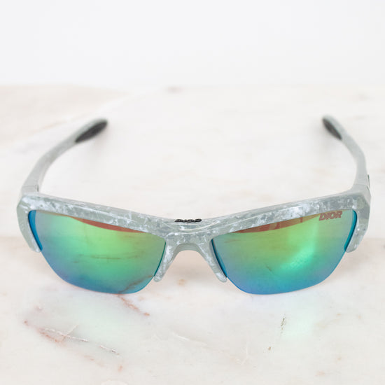 Sunglasses with reflective lenses on a light marble background
