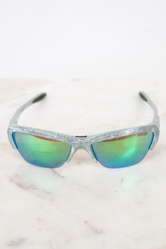 Sunglasses with reflective lenses on a light marble background