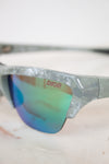 Close-up of a pair of sunglasses with 'Dior' branding on a blurred background
