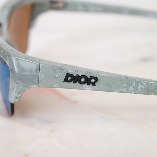 Sunglasses with Dior logo on a marble surface