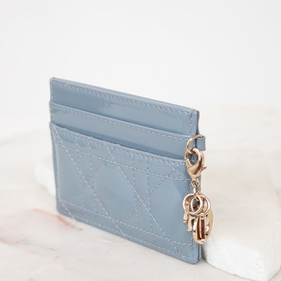 Card holder with gold charm details against white surface