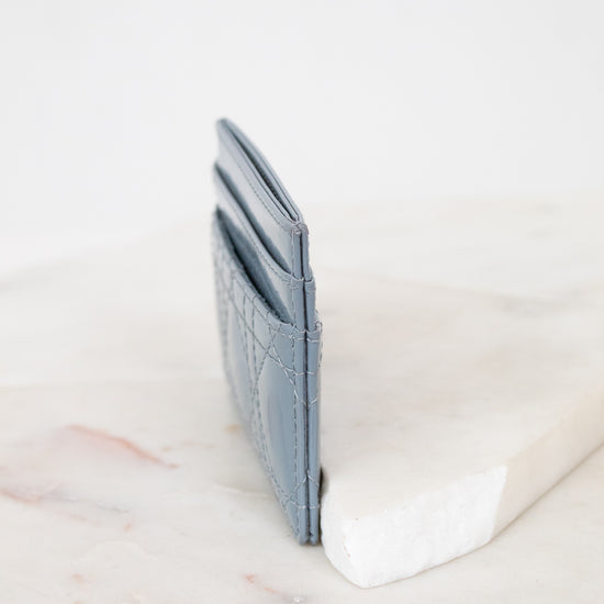 Side view of light blue card holder against marble surface