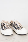 White sneakers with navy and white pattern on a light gray background