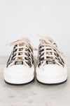 White sneakers with navy and white patterned accents on a light background