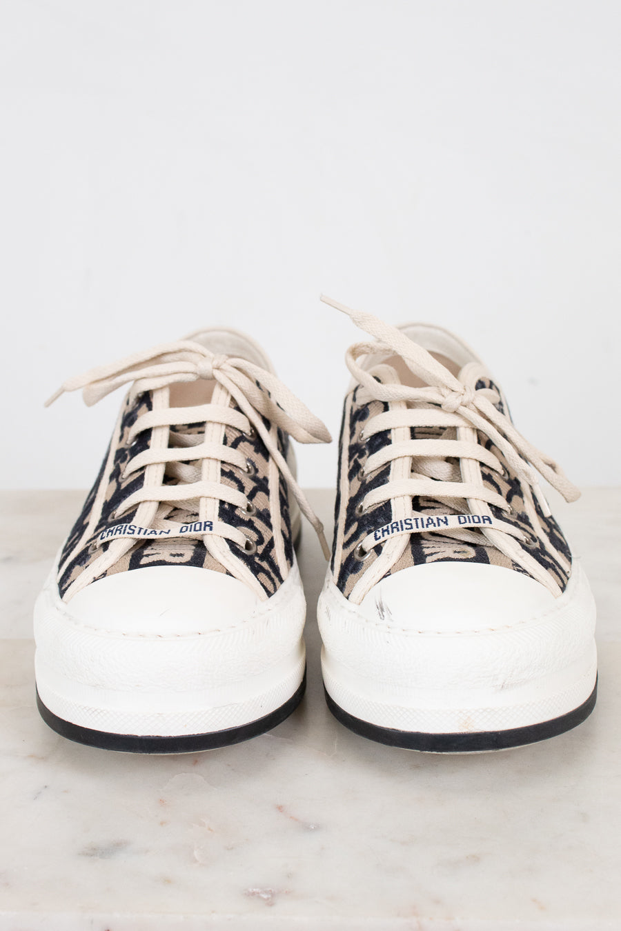 White sneakers with navy and white patterned accents on a light background
