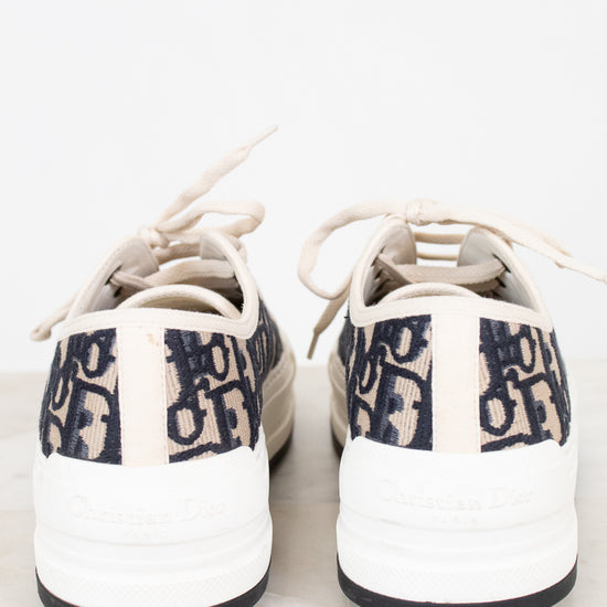 White sneakers with navy text on a white background