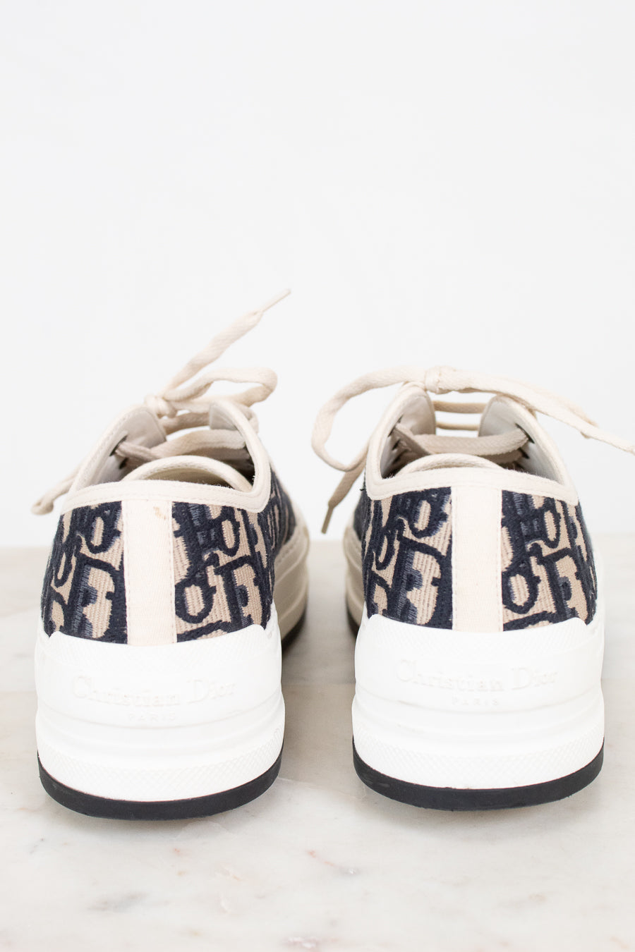 White sneakers with navy text on a white background