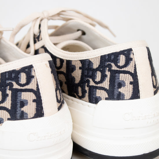 White sneakers with navy text pattern on a white background